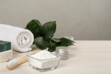 Photo of Composition with tooth powder and green leaves on white wooden table, space for text