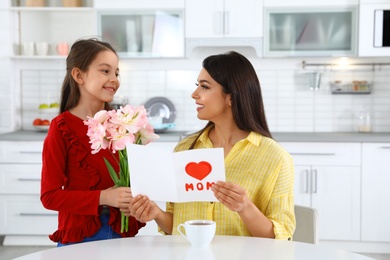 Daughter congratulating her mom in kitchen. Happy Mother's Day