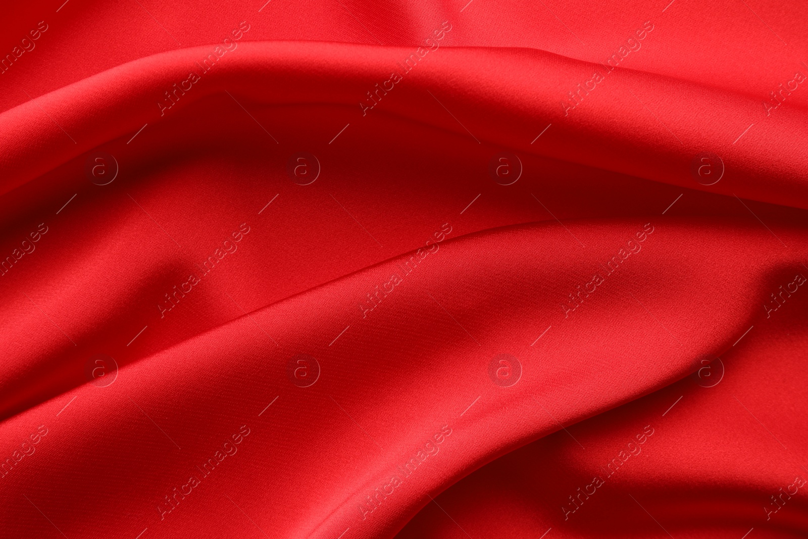 Photo of Crumpled red silk fabric as background, top view