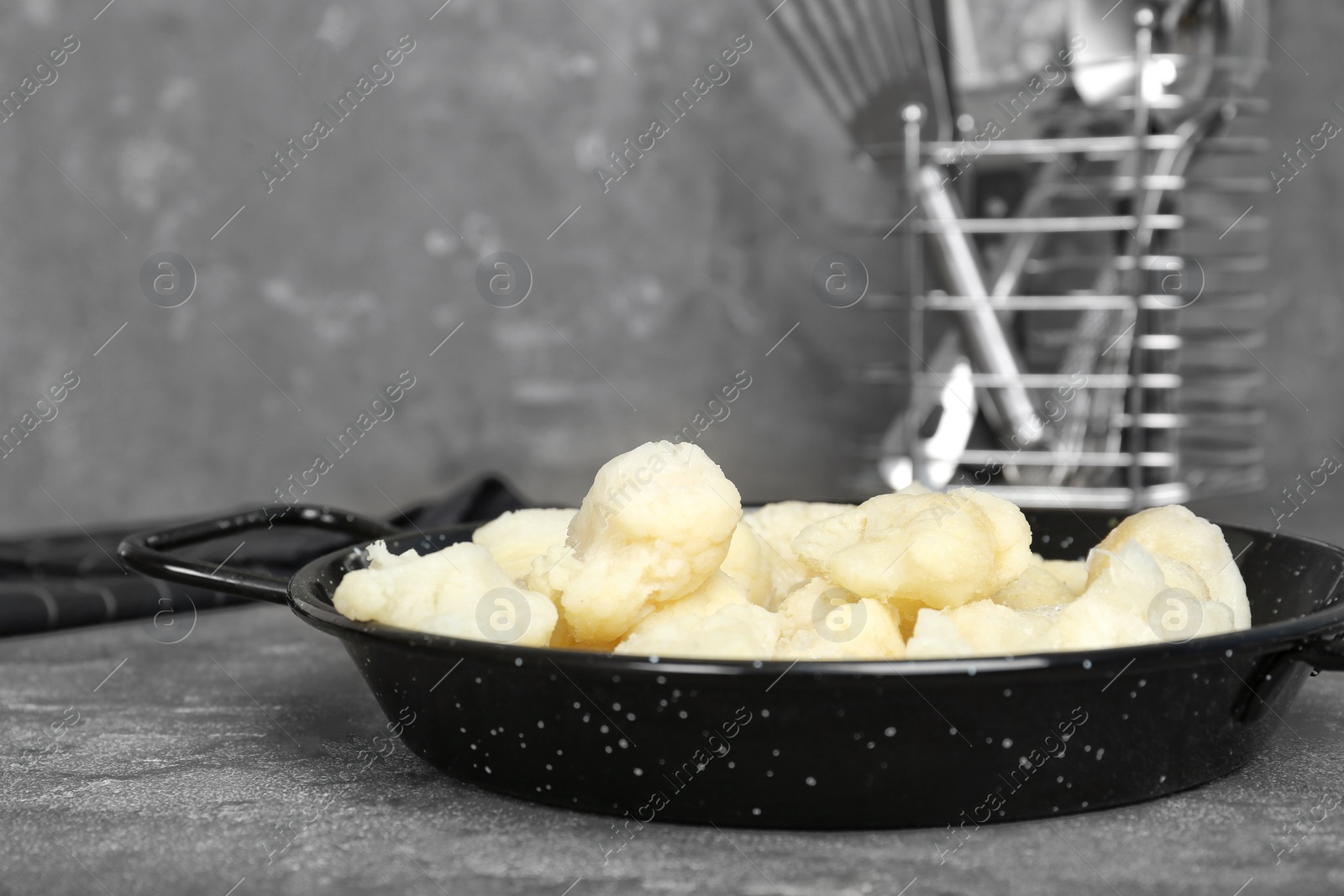 Photo of Frying pan with frozen cauliflower on table. Vegetable preservation