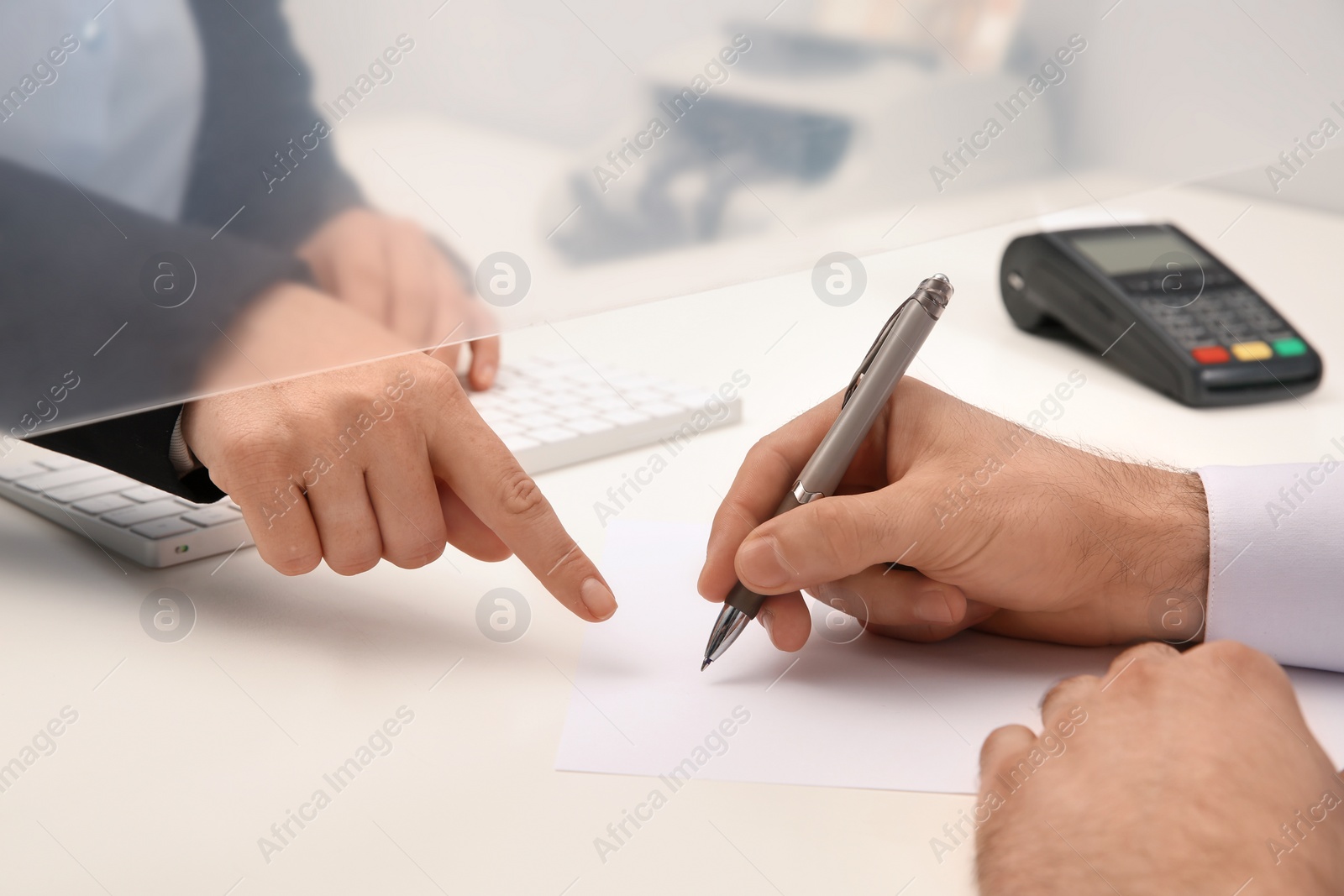 Photo of Man filling blank at cash department window, closeup