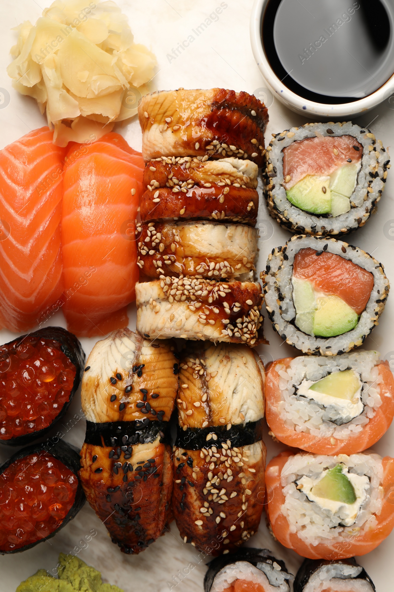 Photo of Set of delicious sushi rolls on board, top view