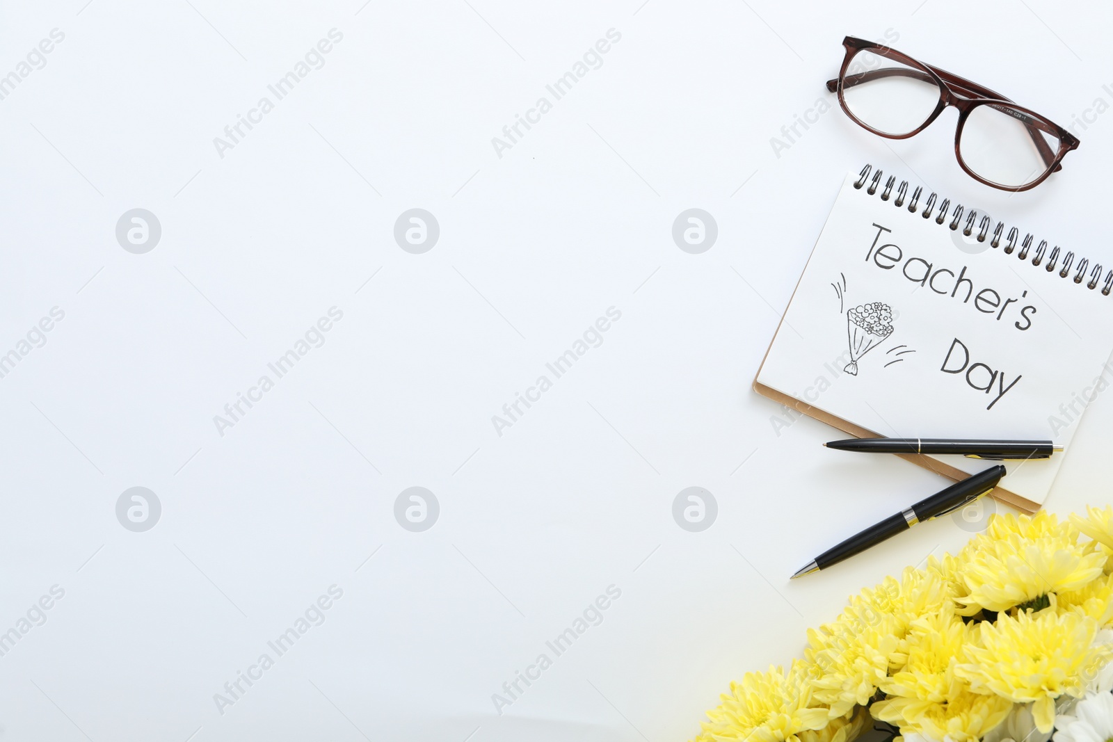 Photo of Beautiful flowers, glasses and notebook with words TEACHER'S DAY on white background, flat lay. Space for text