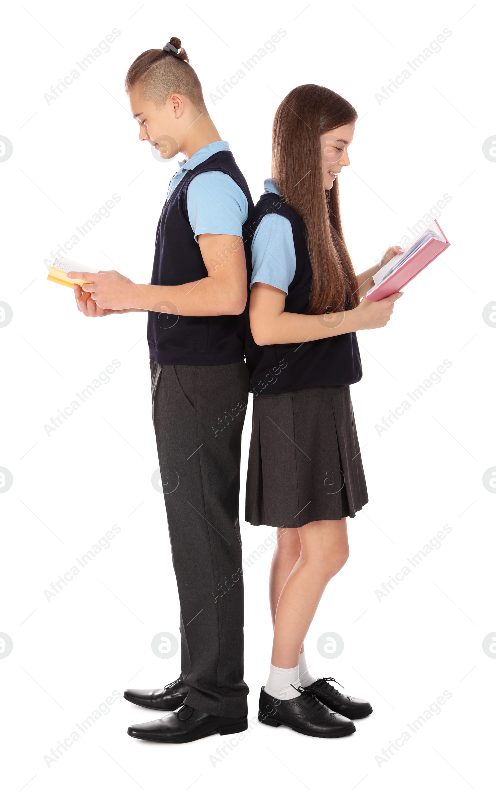 Photo of Full length portrait of teenagers in school uniform with books on white background