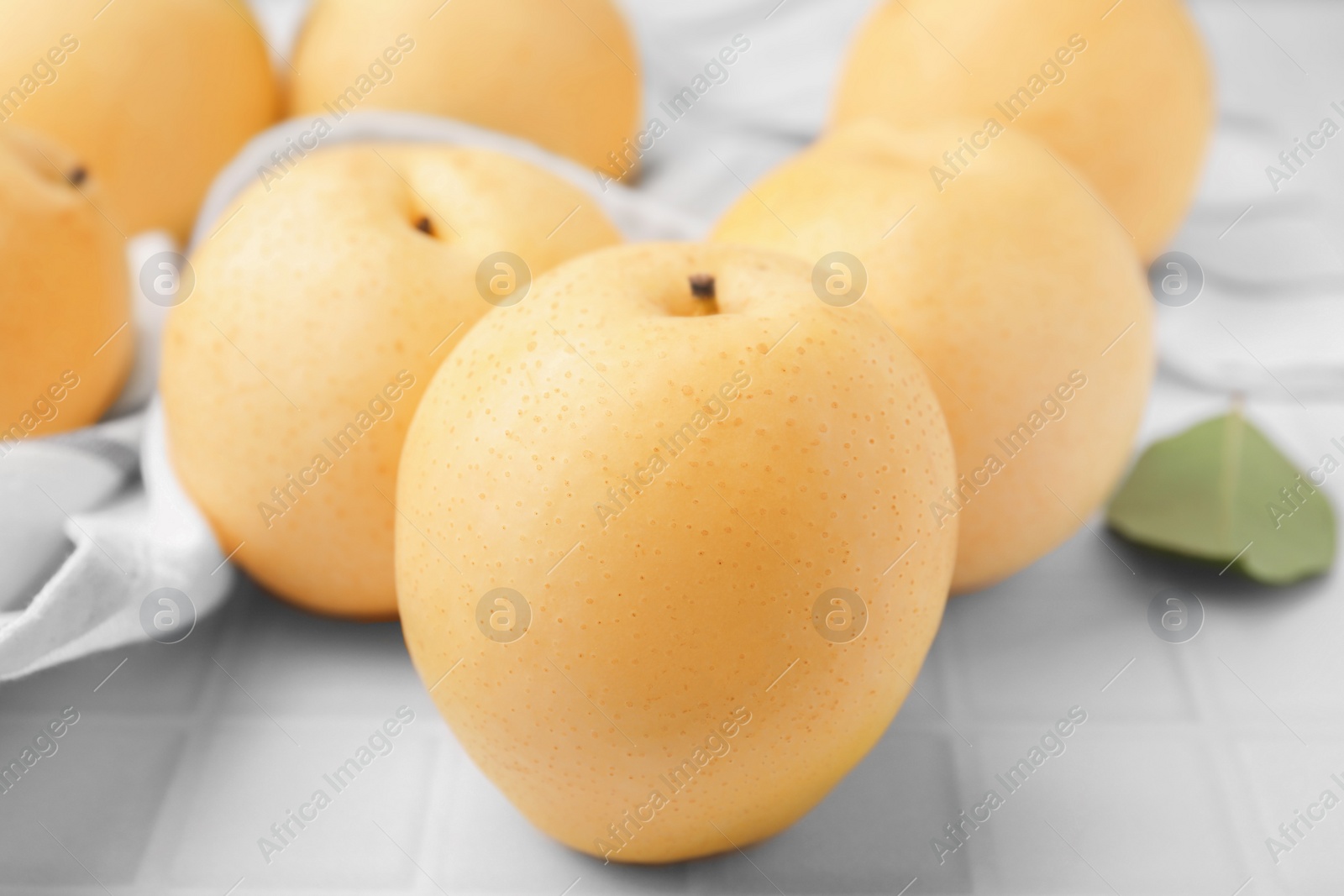 Photo of Delicious apple pears on white tiled table, closeup