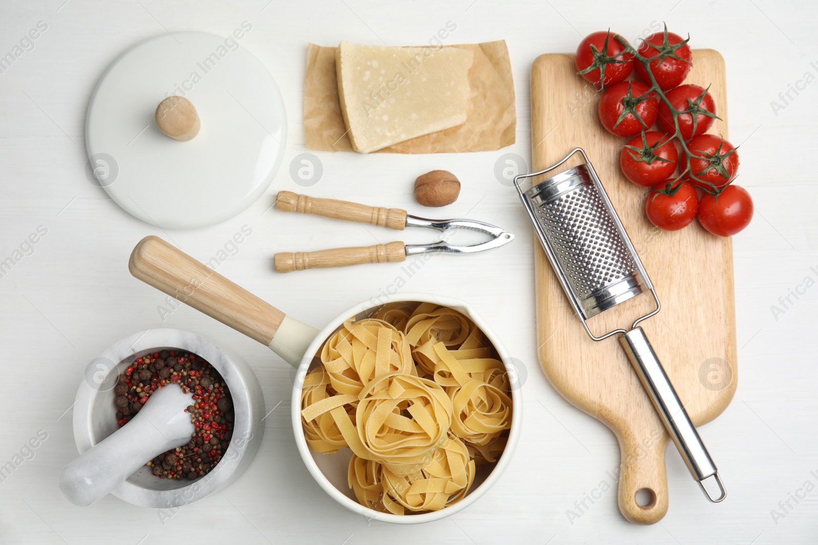 Photo of Cooking utensils and ingredients on white wooden table, flat lay