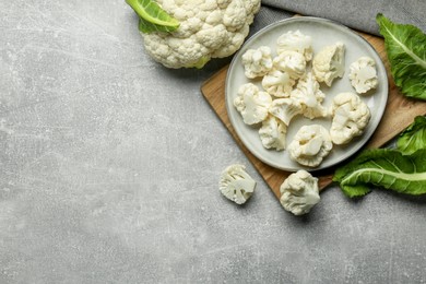 Photo of Cut and whole cauliflowers on grey table, flat lay. Space for text