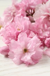 Beautiful sakura tree blossoms on white wooden table, closeup