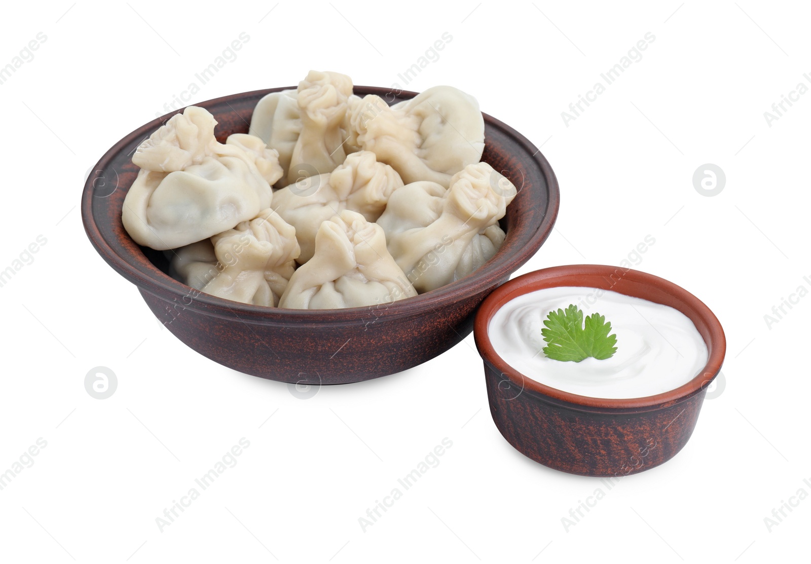 Photo of Tasty khinkali (dumplings) with sauce and parsley isolated on white. Georgian cuisine