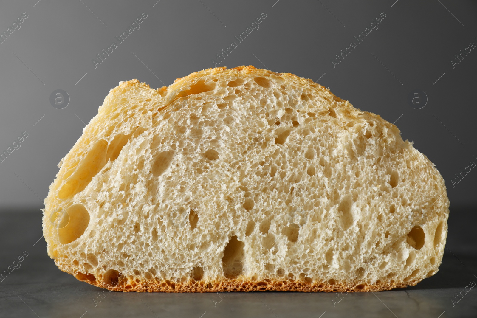 Photo of Freshly baked cut sourdough on grey table, closeup