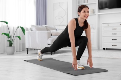 Photo of Morning routine. Happy woman doing stretching exercise at home. Space for text