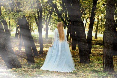 Photo of Beautiful girl wearing fairy dress in autumn forest, back view