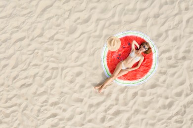 Image of Woman sunbathing on round beach towel at sandy coast, aerial view. Space for text