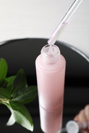 Photo of Dripping of serum into bottle on mirror tray, closeup