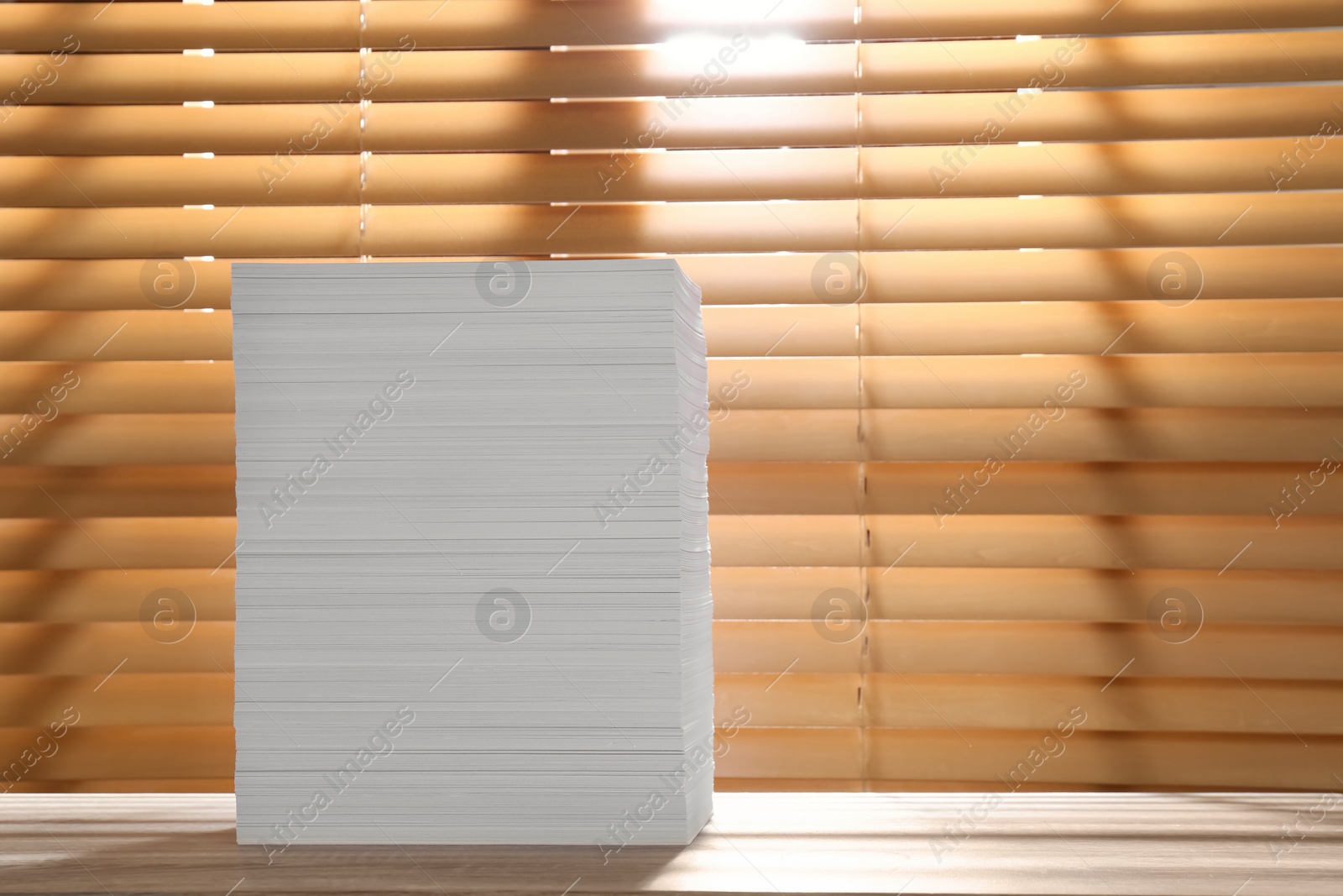 Photo of Stack of paper sheets on wooden table. Space for text