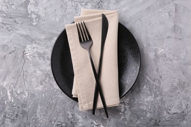 Photo of Elegant setting with stylish cutlery on grey textured table, top view