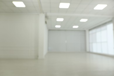 Photo of Empty room with white walls and laminated flooring, blurred view