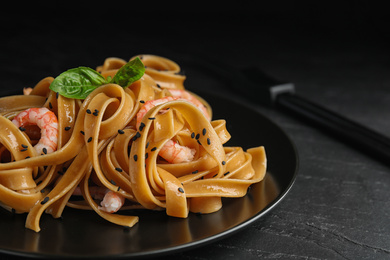 Tasty buckwheat noodles with shrimps on black table, closeup