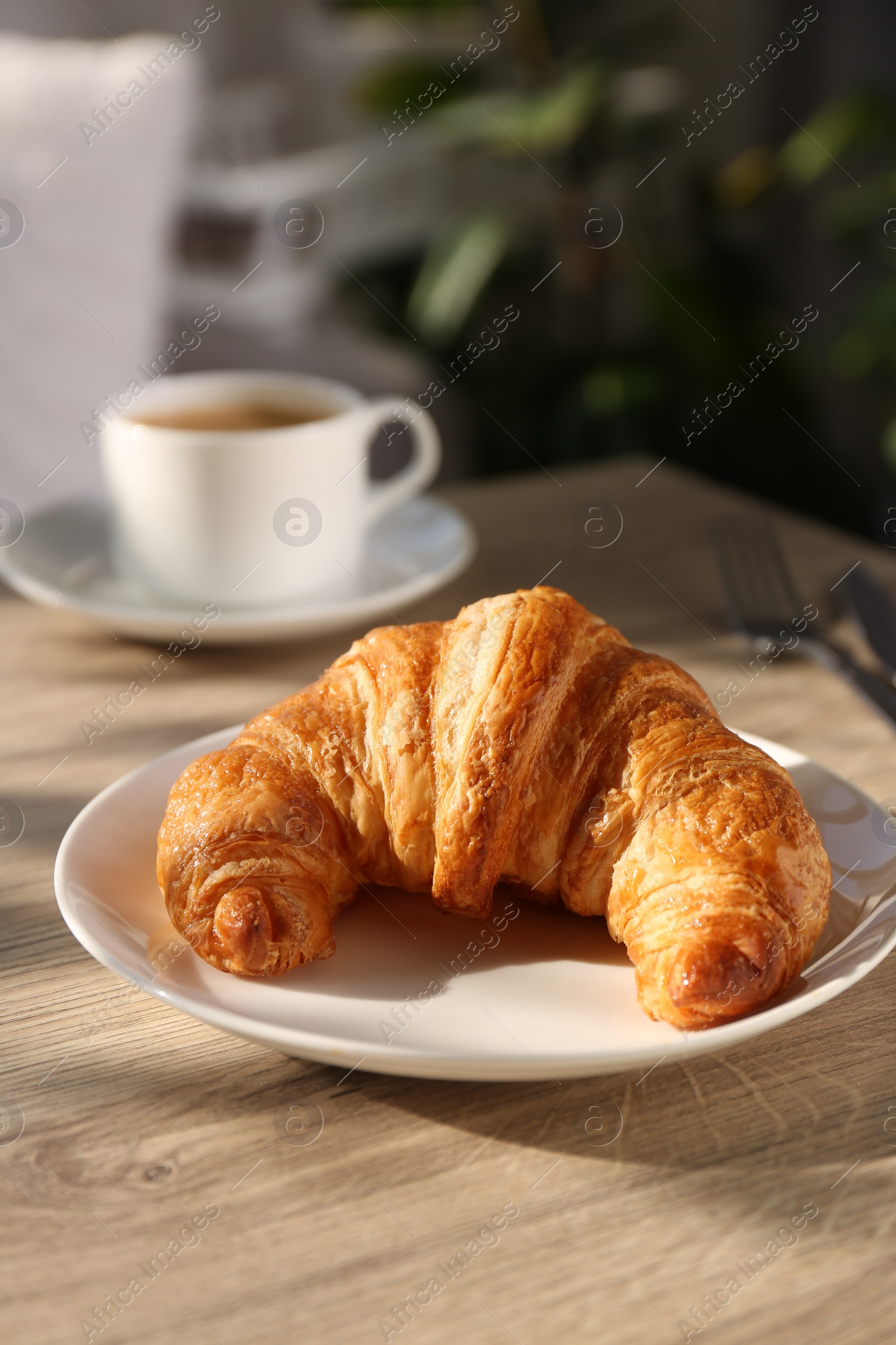 Photo of Delicious fresh croissant served on wooden table