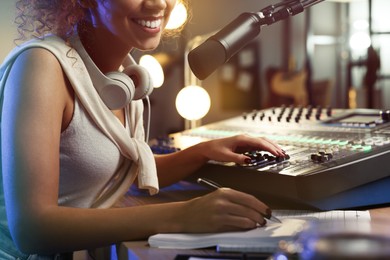 Photo of African American woman working as radio host in modern studio, closeup