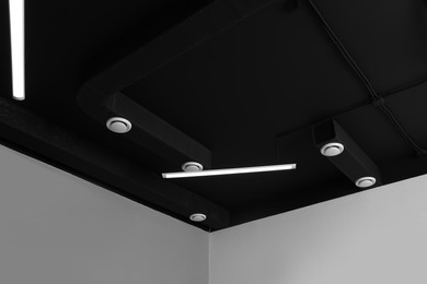 Black ceiling with modern lighting in office