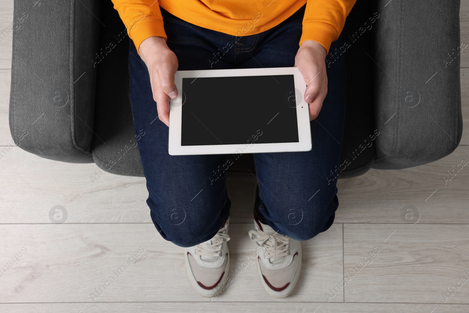 Photo of Man working with tablet in armchair, top view