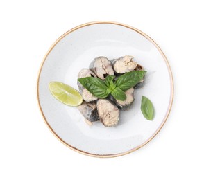 Photo of Plate with canned mackerel chunks, lime and basil isolated on white, top view