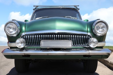 Photo of Beautiful green retro car on street, low angle view