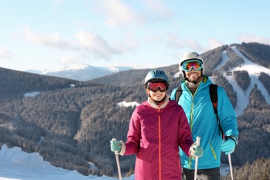 Couple with ski equipment spending winter vacation in mountains