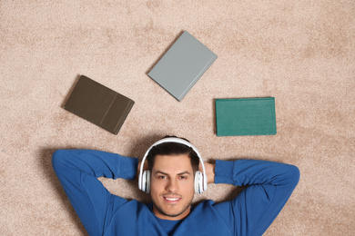 Man listening to audiobook on floor, top view