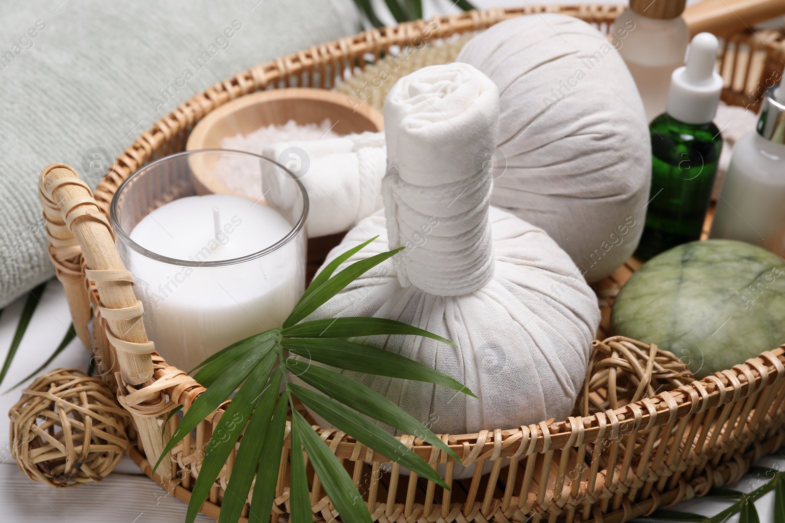 Photo of Spa composition with herbal massage bags and cosmetic products on white table