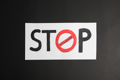 Phrase STOP VIOLENCE on black background, top view