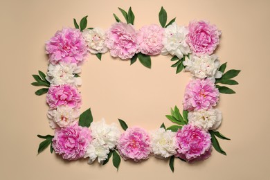Frame made of beautiful peony flowers and green leaves on beige background, flat lay. Space for text