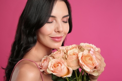 Photo of Young woman with beautiful bouquet on pink background