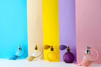 Photo of Composition with different bottles of perfume on color background