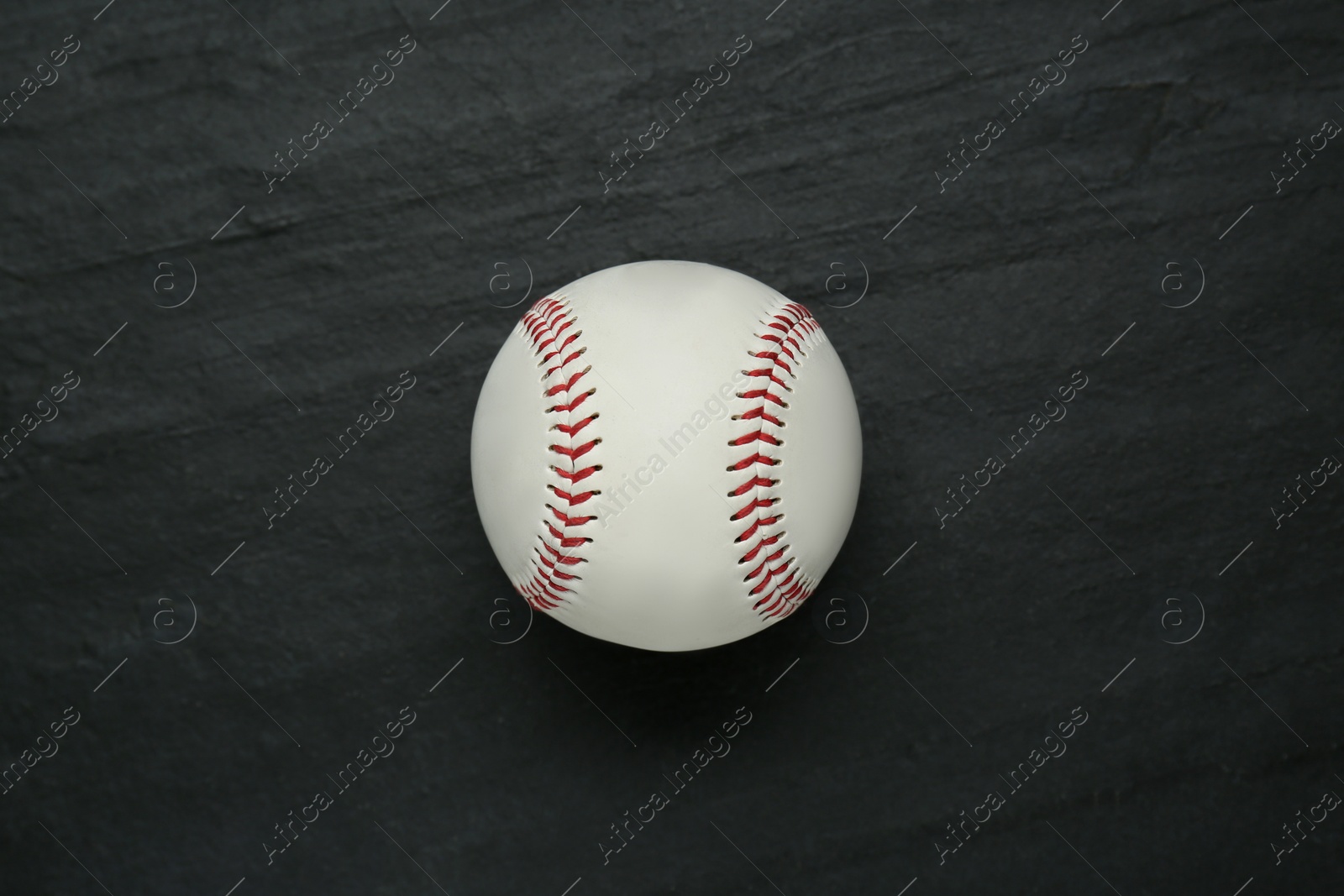 Photo of Baseball ball on black slate background, top view. Sports game