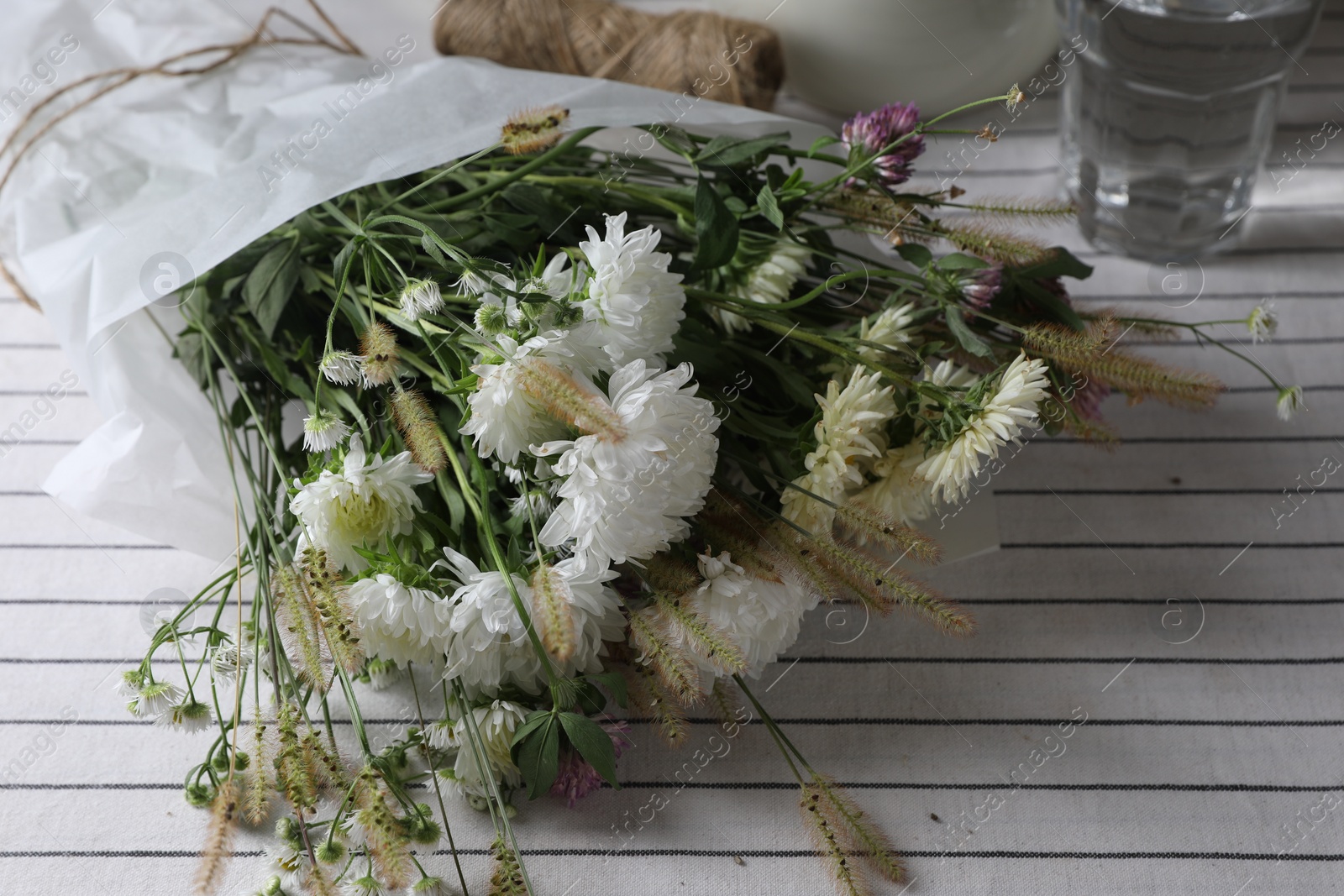 Photo of Bouquet of beautiful wild flowers and spikelets on table