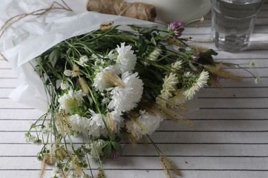 Bouquet of beautiful wild flowers and spikelets on table