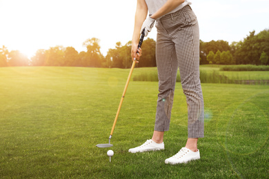 Image of Woman playing golf in park on sunny day. Sport and leisure