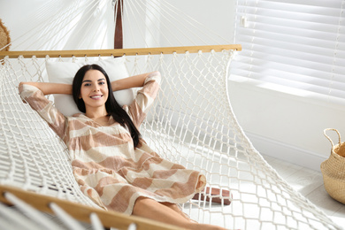 Young woman relaxing in hammock at home