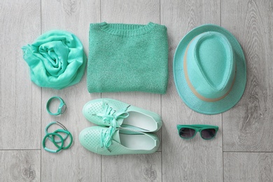 Photo of Flat lay composition with set of mint clothes and accessories on wooden background
