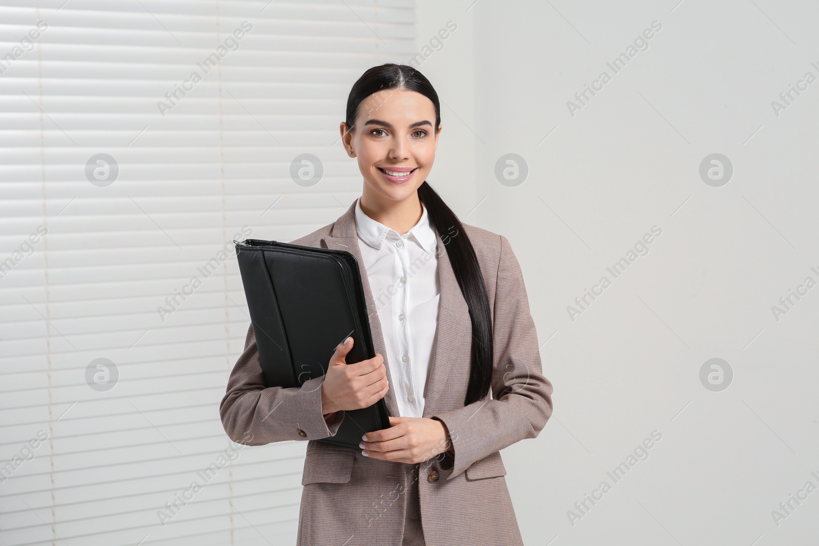 Photo of Beautiful real estate agent with documents indoors