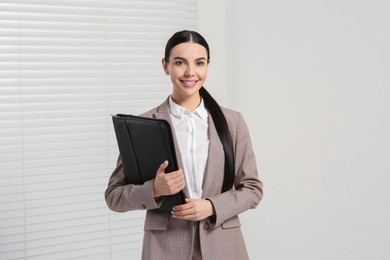 Photo of Beautiful real estate agent with documents indoors
