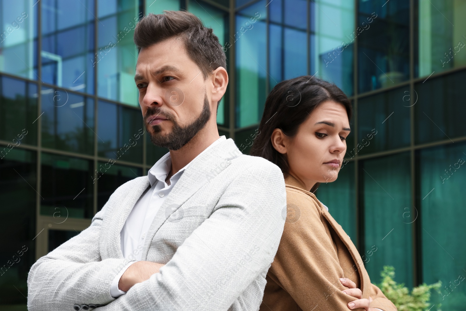 Photo of Upset arguing couple near building outdoors. Relationship problems