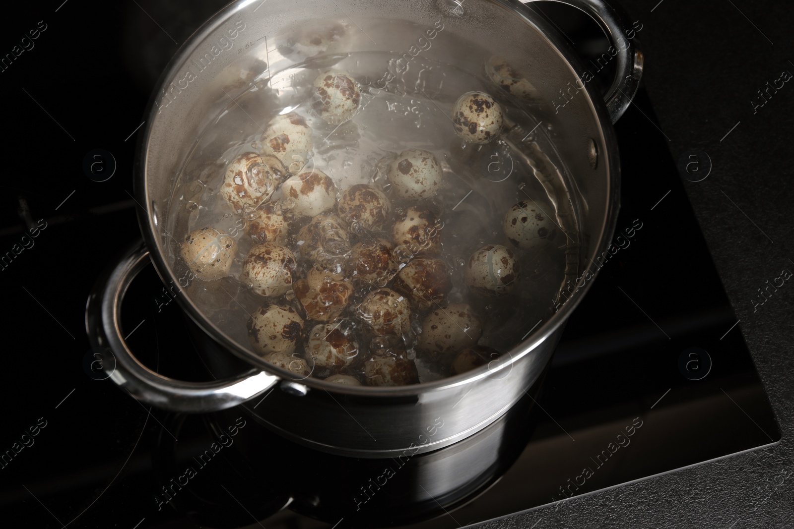 Photo of Cooking quail eggs in pot on electric stove