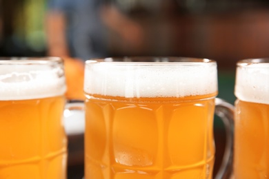 Glasses of tasty beer on blurred background, closeup