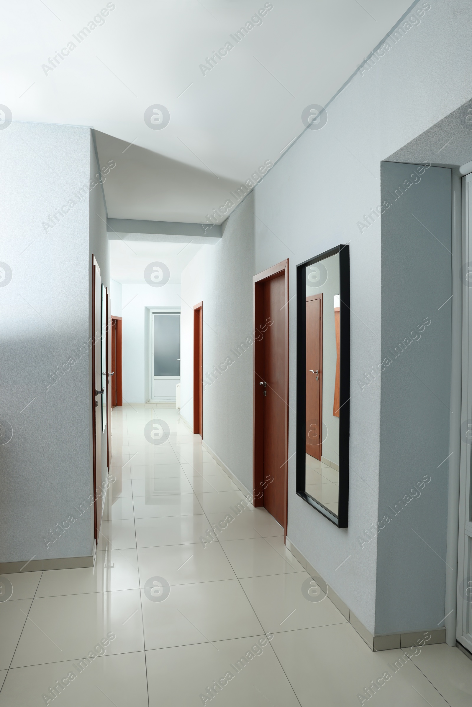 Photo of Modern empty office corridor with white walls and mirror