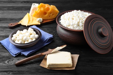 Clay dishware with fresh dairy products on black wooden table