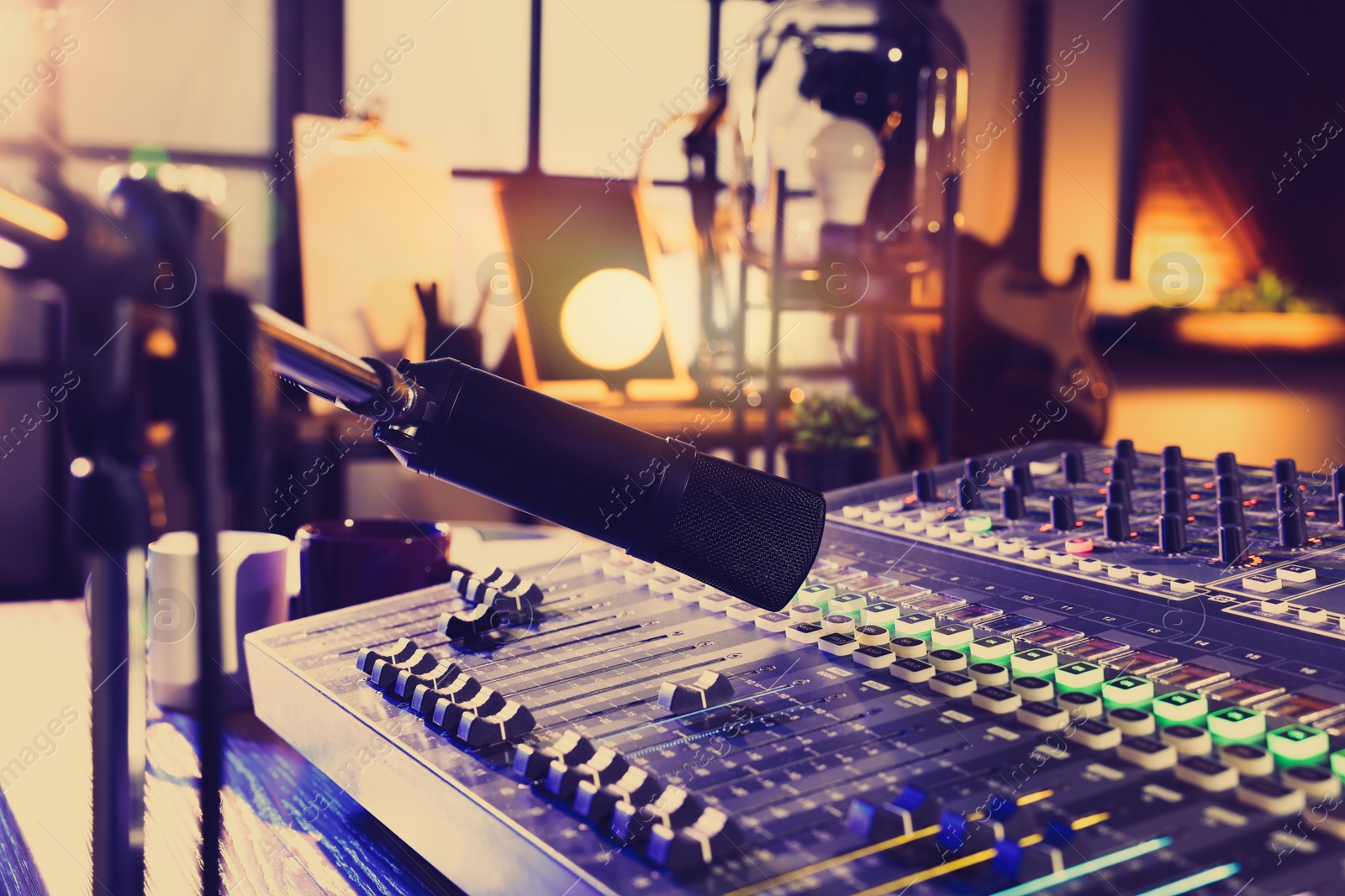 Photo of Microphone over professional mixing console on table in radio studio