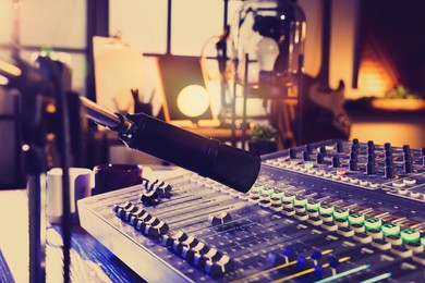 Microphone over professional mixing console on table in radio studio